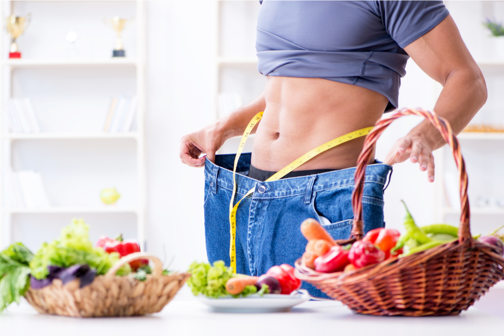 Frau mit zu großer Hose und Gemüsekorb symbolisch für das online Abnehmprogramm