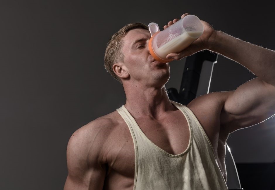 Eiweiß dargestellt von Bodybuilder mit Shake