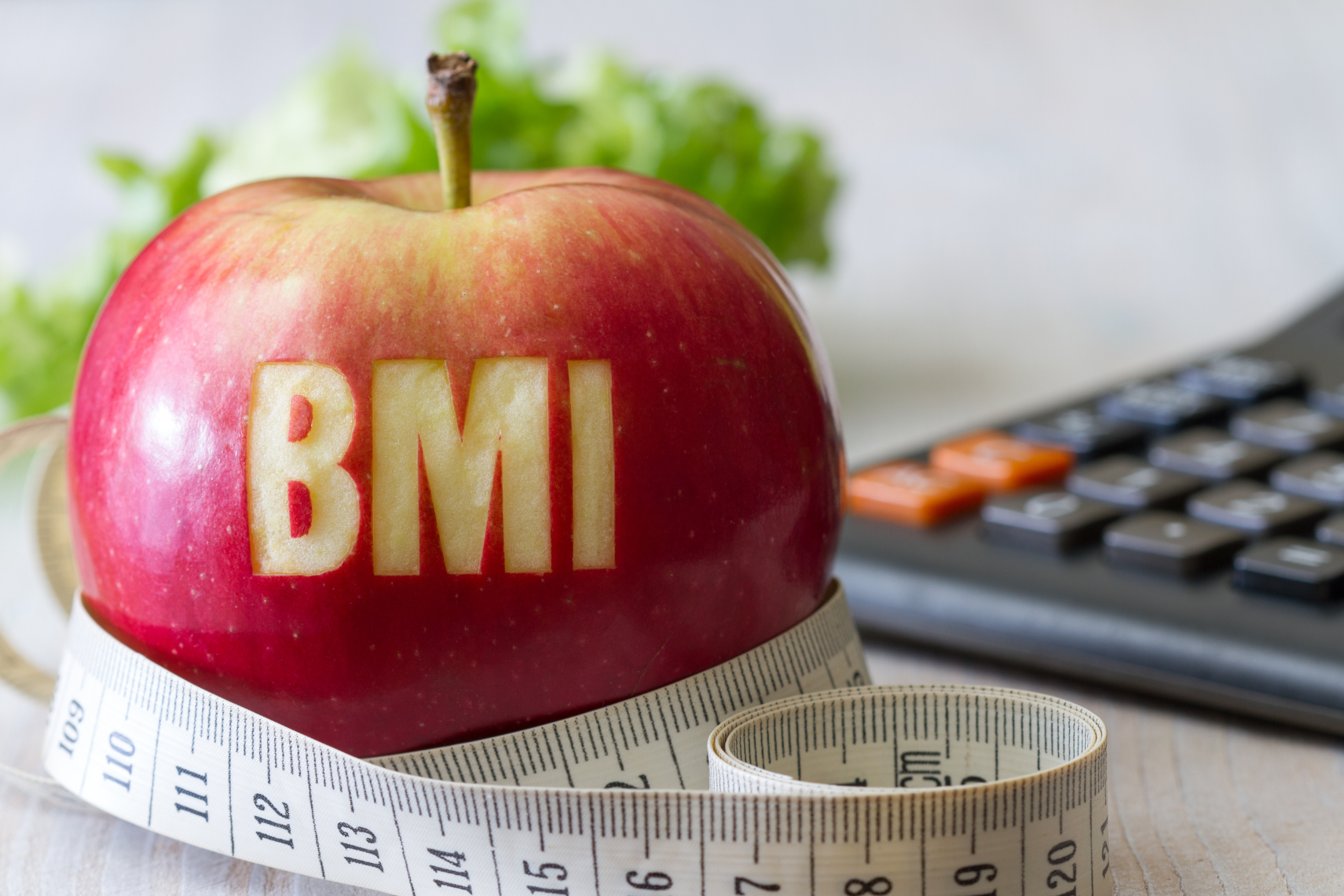 Welcher BMI ist normal - symbolisiert durch Apfel und Maßband