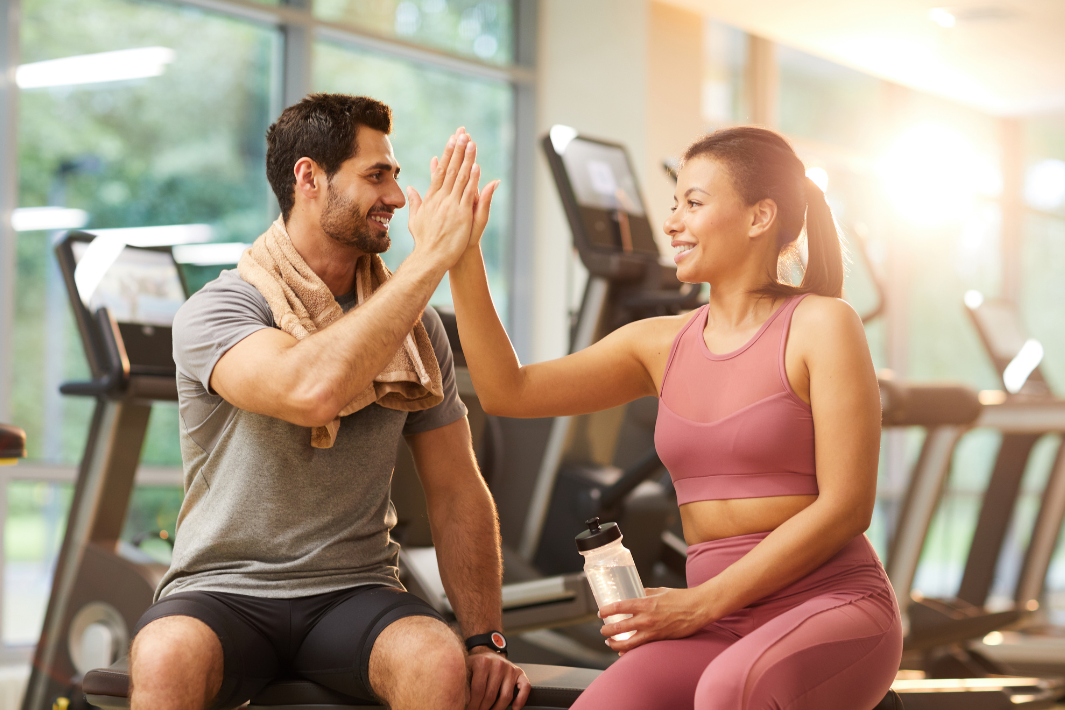 Fitnesscouple im Gym nutzt Kurse und Gerätetraining