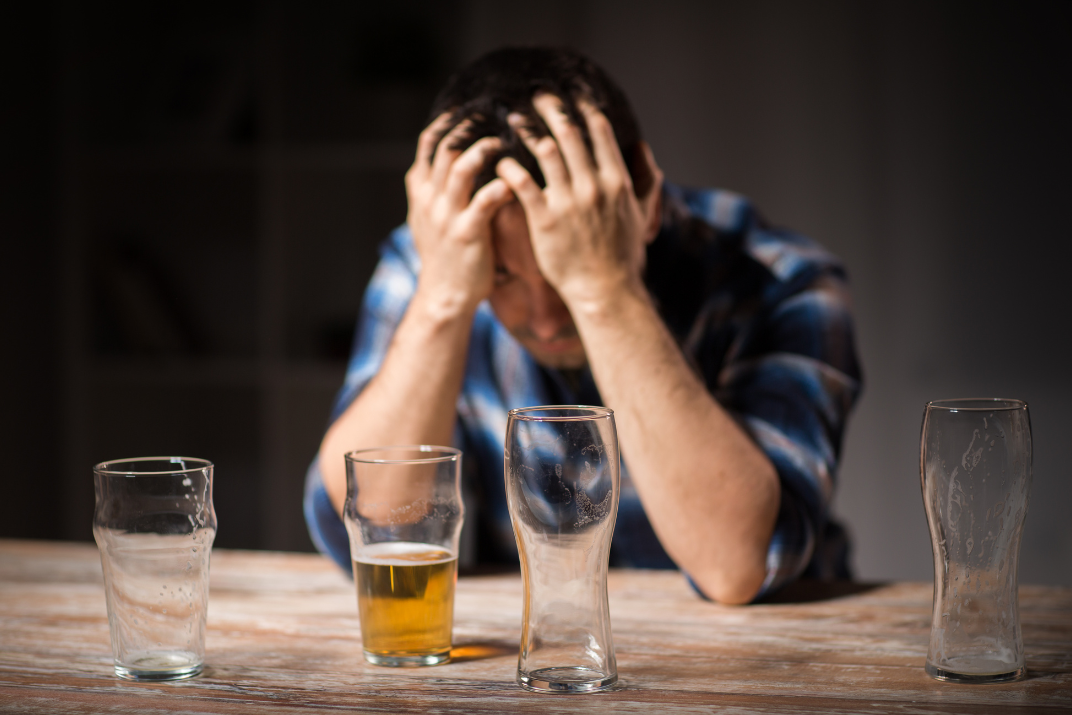 Alltagsdroge Alkohol symbolisiert durch Mann mit 4 leeren Gläsern
