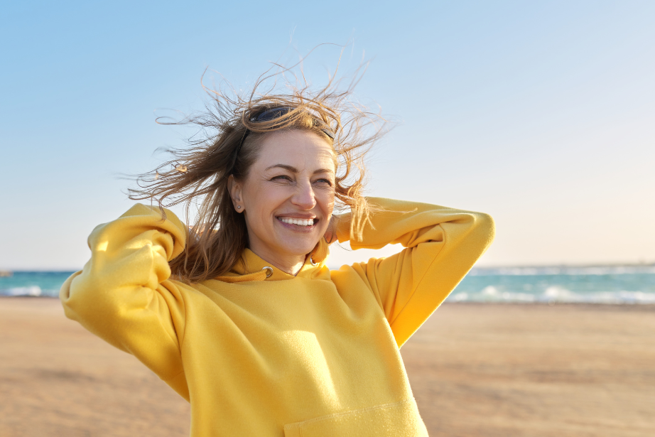 glückliche ältere Frau am Strand symbolisch für Abnehmen ab 40