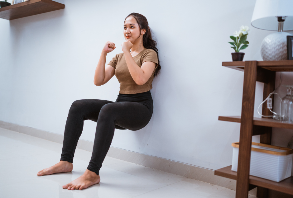 Kann man mit Wand-Pilates abnehmen, Frau macht Kniebeugen an Wand