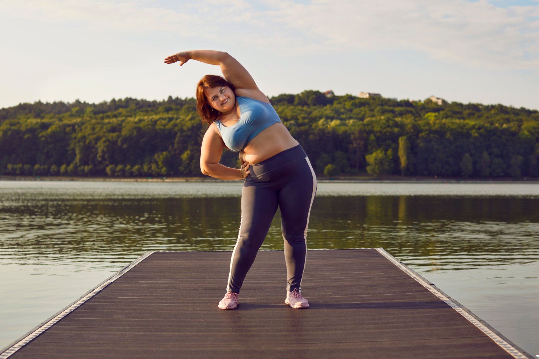 Gewicht reduzieren dargestellt von übergewichtiger Frau beim Sport in der Natur