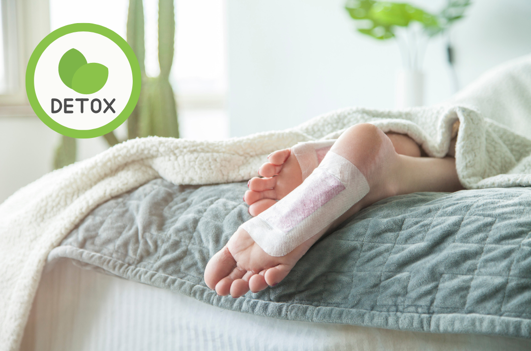 Detox-Pflaster zum Abnehmen bei Frau an Füßen im Bett