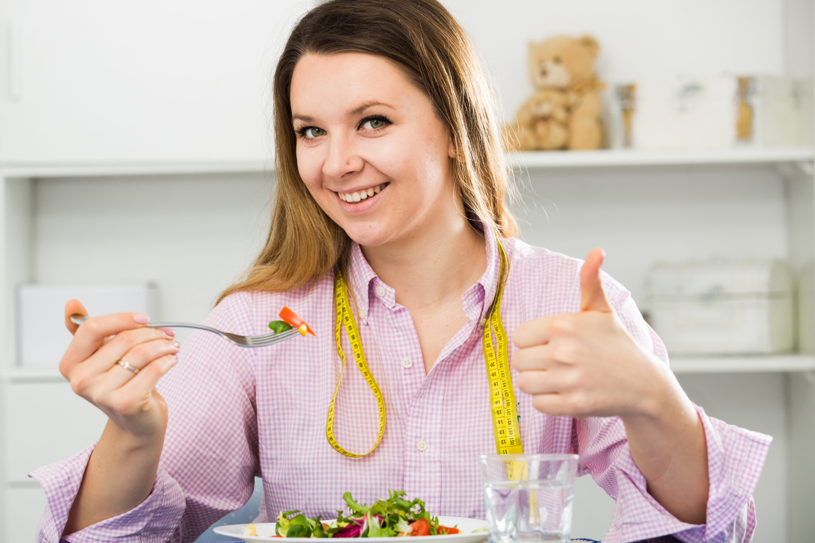 Abnehmen ohne Jojo-Effekt symbolisiert durch Frau mit Salat-Teller und Maßband