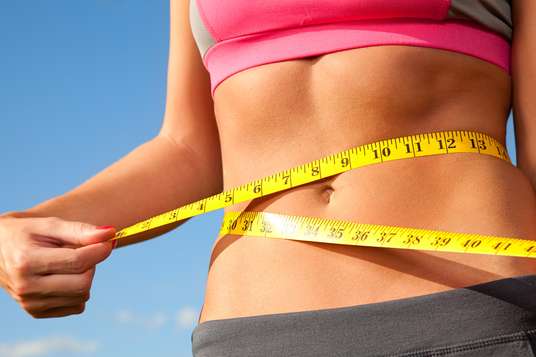 Produkte zum Abnehmen symbolisiert von Frau mit Maßband