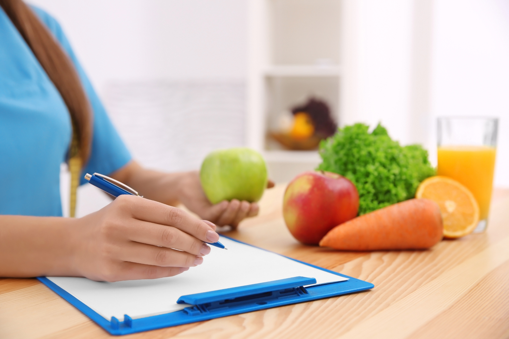 Kalorienbilanz wird von Frau auf Papier errechnet, neben Obst