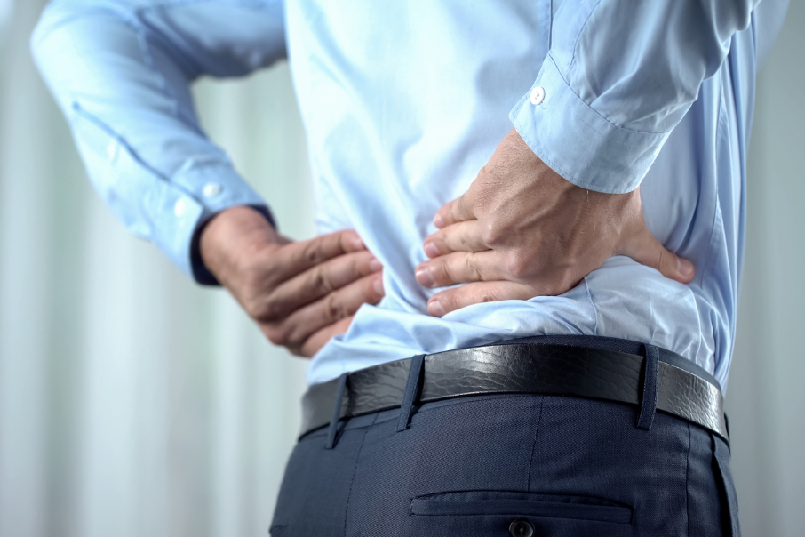 Bandscheibenvorfall symbolisiert von Mann im Anzug mit Rückenschmerzen