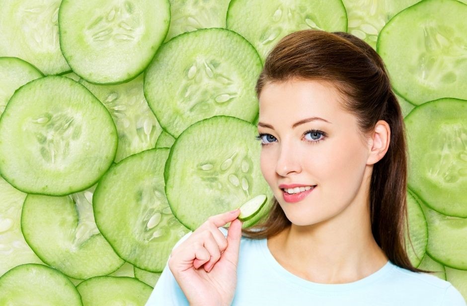 Gurken-Diät dargestellt von Frau und vielen Scheiben Gurken im Hintergrund