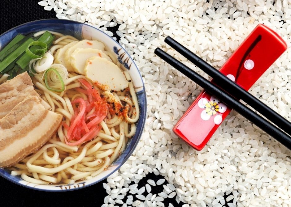 Okinawa-Diät dargestellt von Reiskörnern, traditionellem japanischen Gericht und Stäbchen